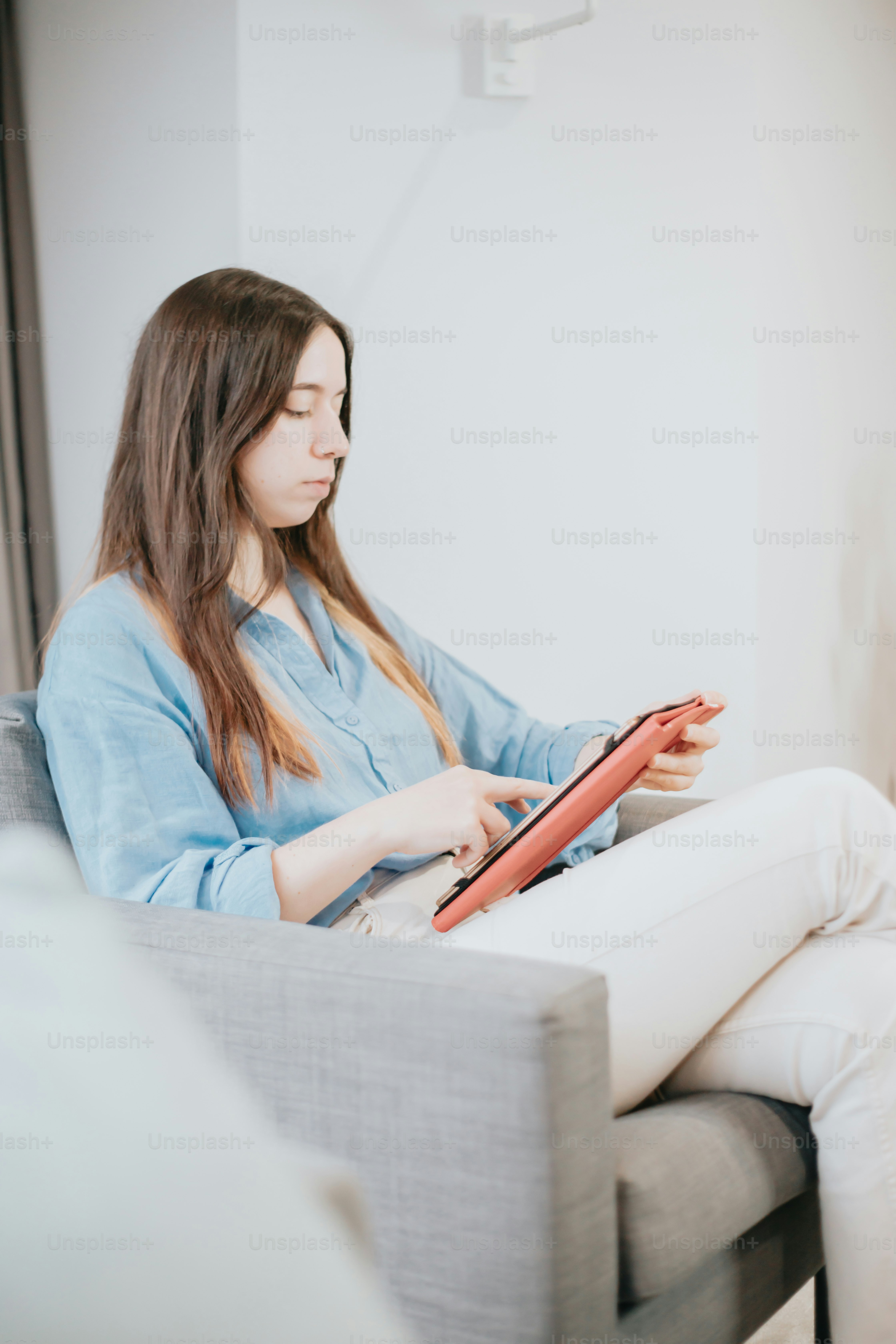 Eine Frau sitzt auf einer Couch und liest ein Buch