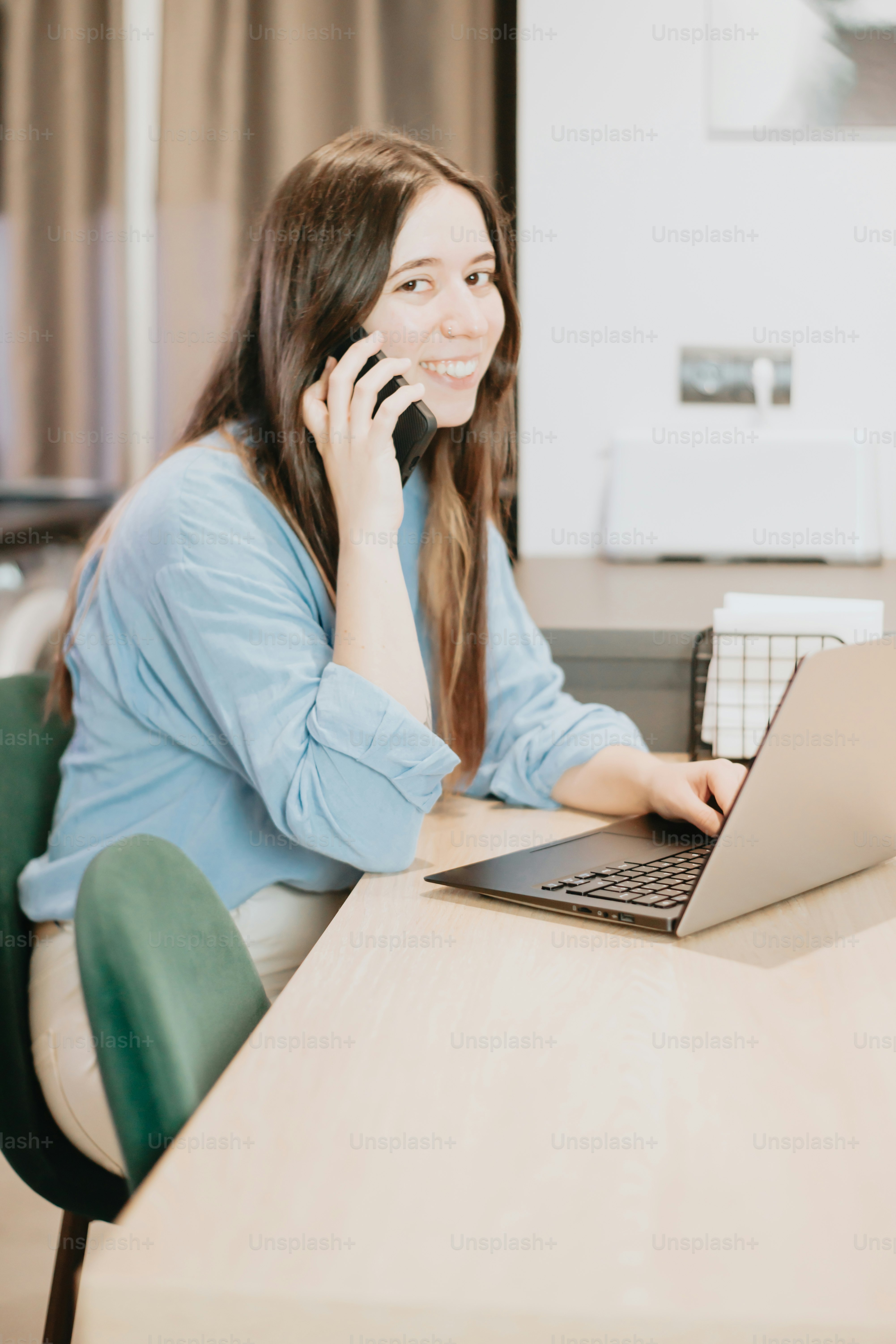 uma mulher sentada em uma mesa com um laptop