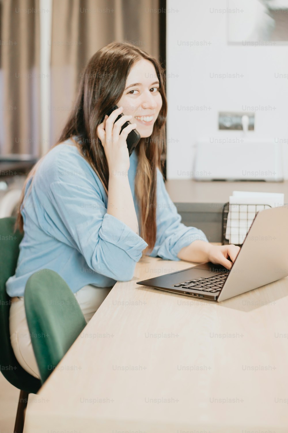 Una mujer sentada en una mesa con una computadora portátil