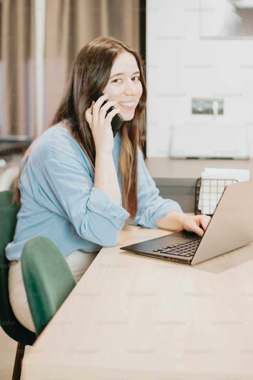 a woman sitting at a table with a laptop