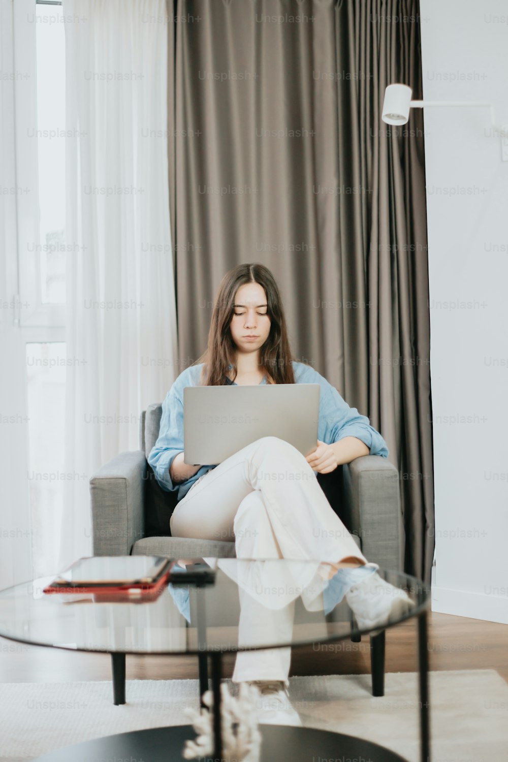 a woman sitting on a chair with a laptop