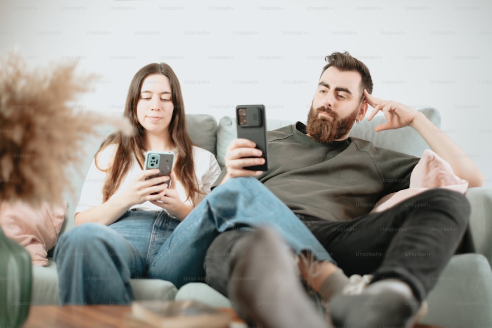 Un gruppo di persone sedute su un divano che guardano i loro telefoni