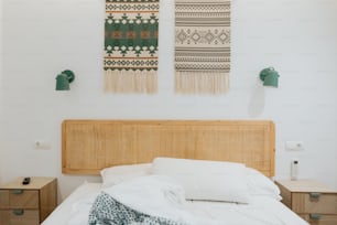 a bed with a white comforter and two wall hangings