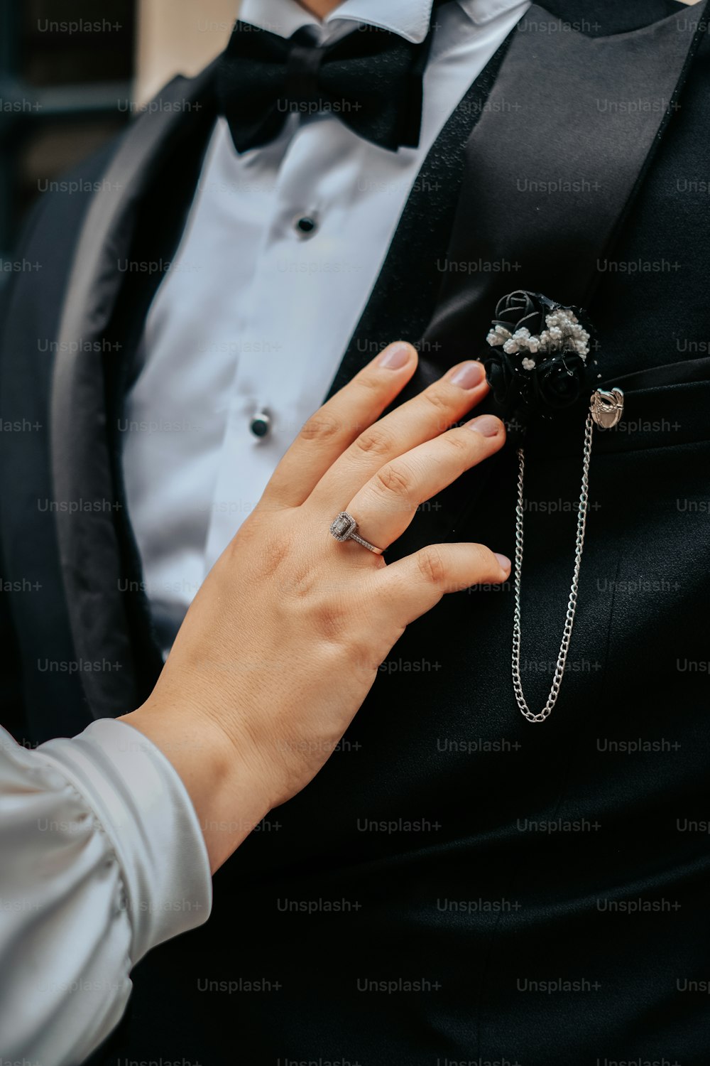 a person in a tuxedo holding a ring
