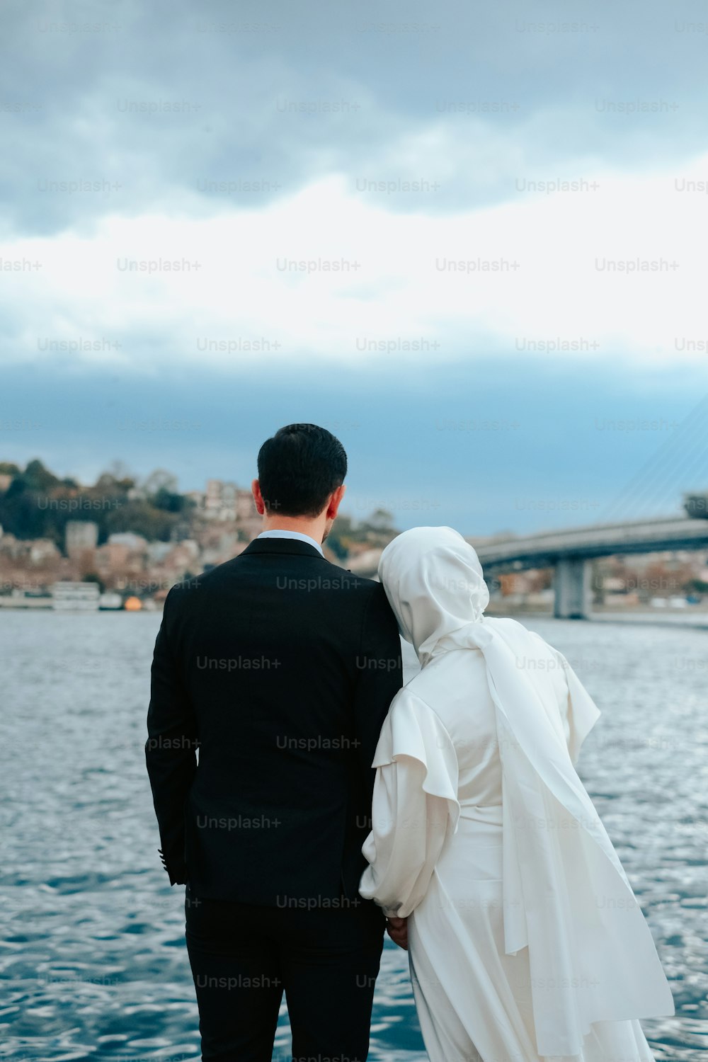 a man and a woman standing next to each other near a body of water