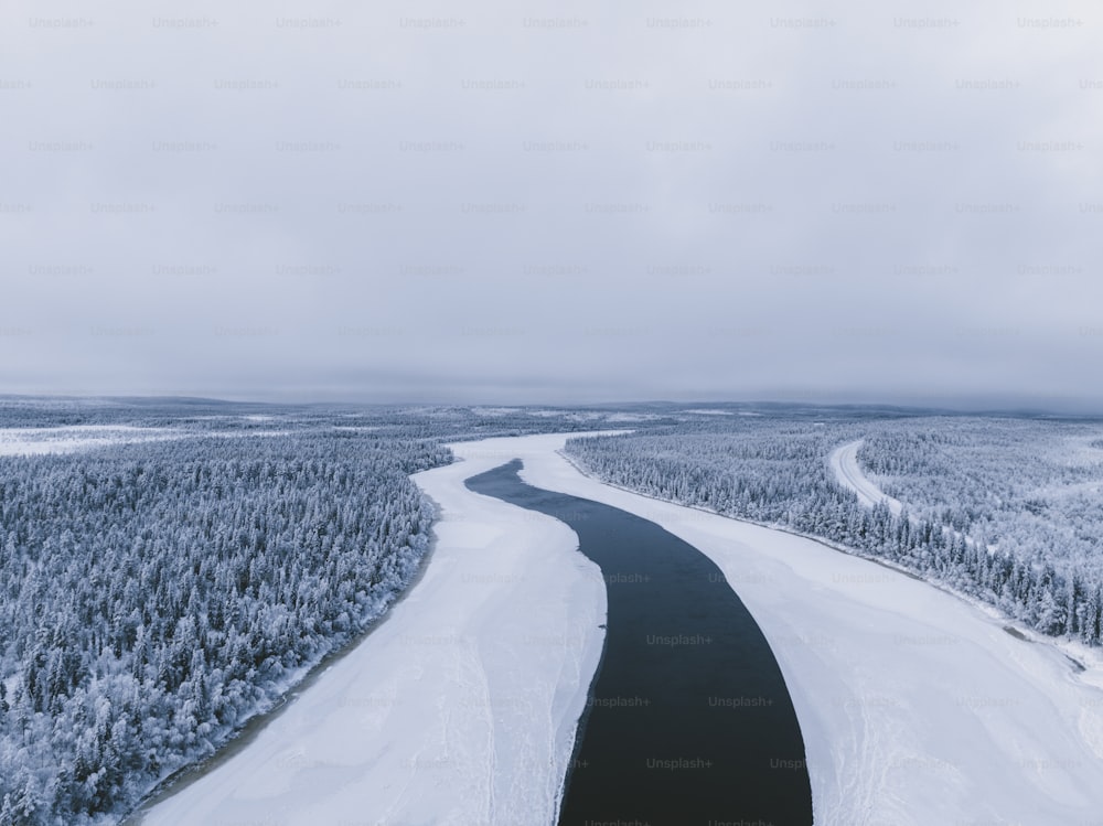 um rio que atravessa uma floresta coberta de neve