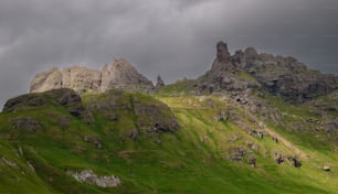 una colina cubierta de hierba con algunas rocas en la parte superior