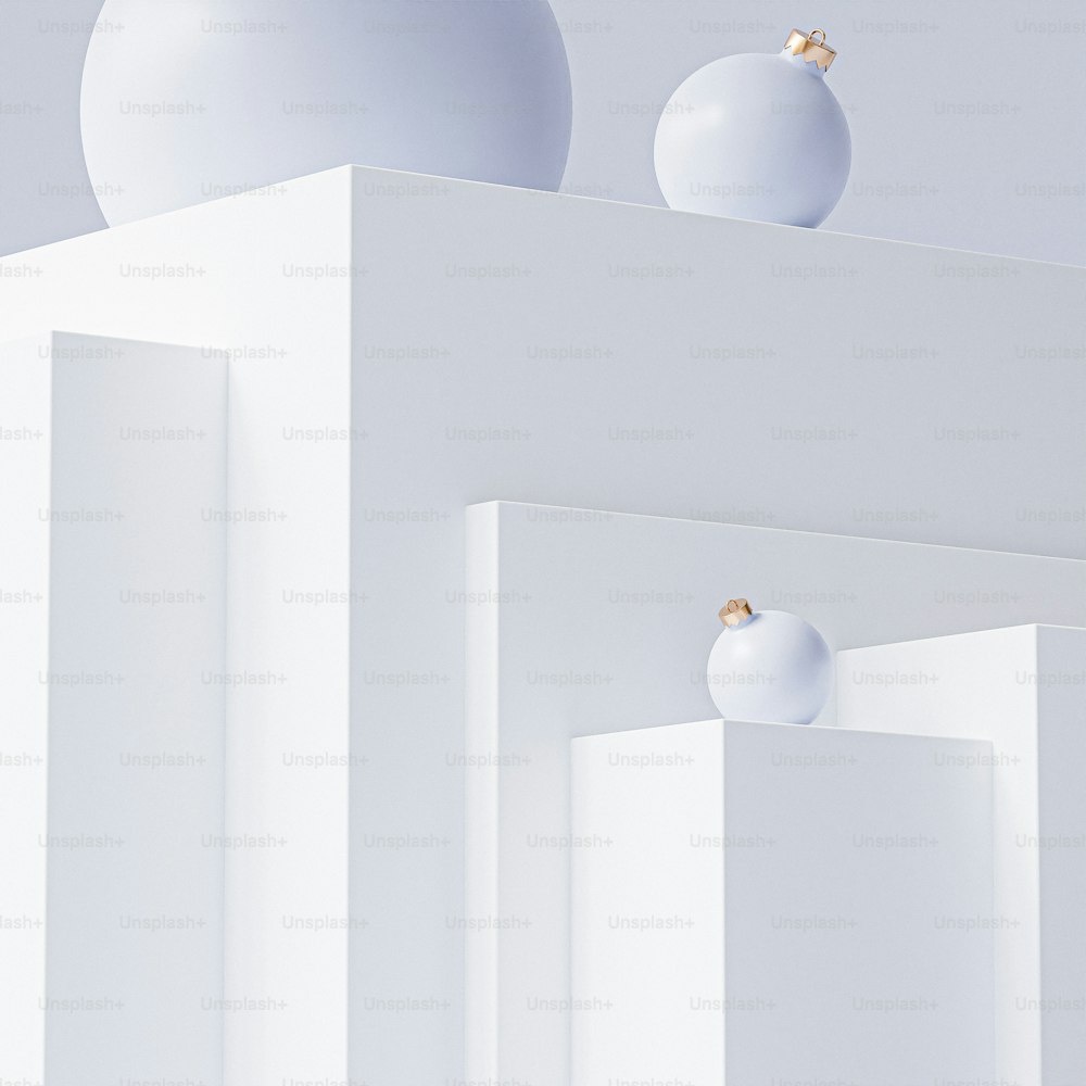 two white balls are on top of a white structure