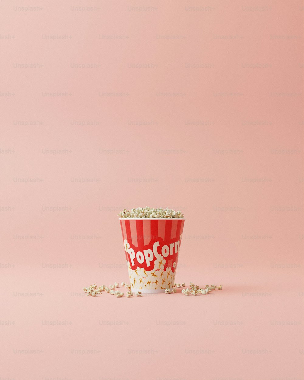 una tazza di popcorn con spruzzate su uno sfondo rosa