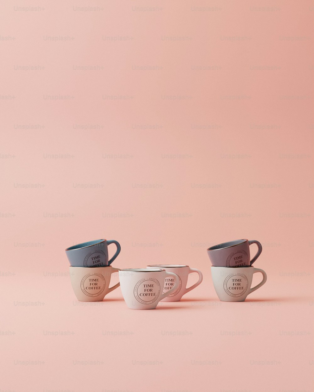 분홍색 배경에 나란히 앉아 있는 세 개의 커피잔
