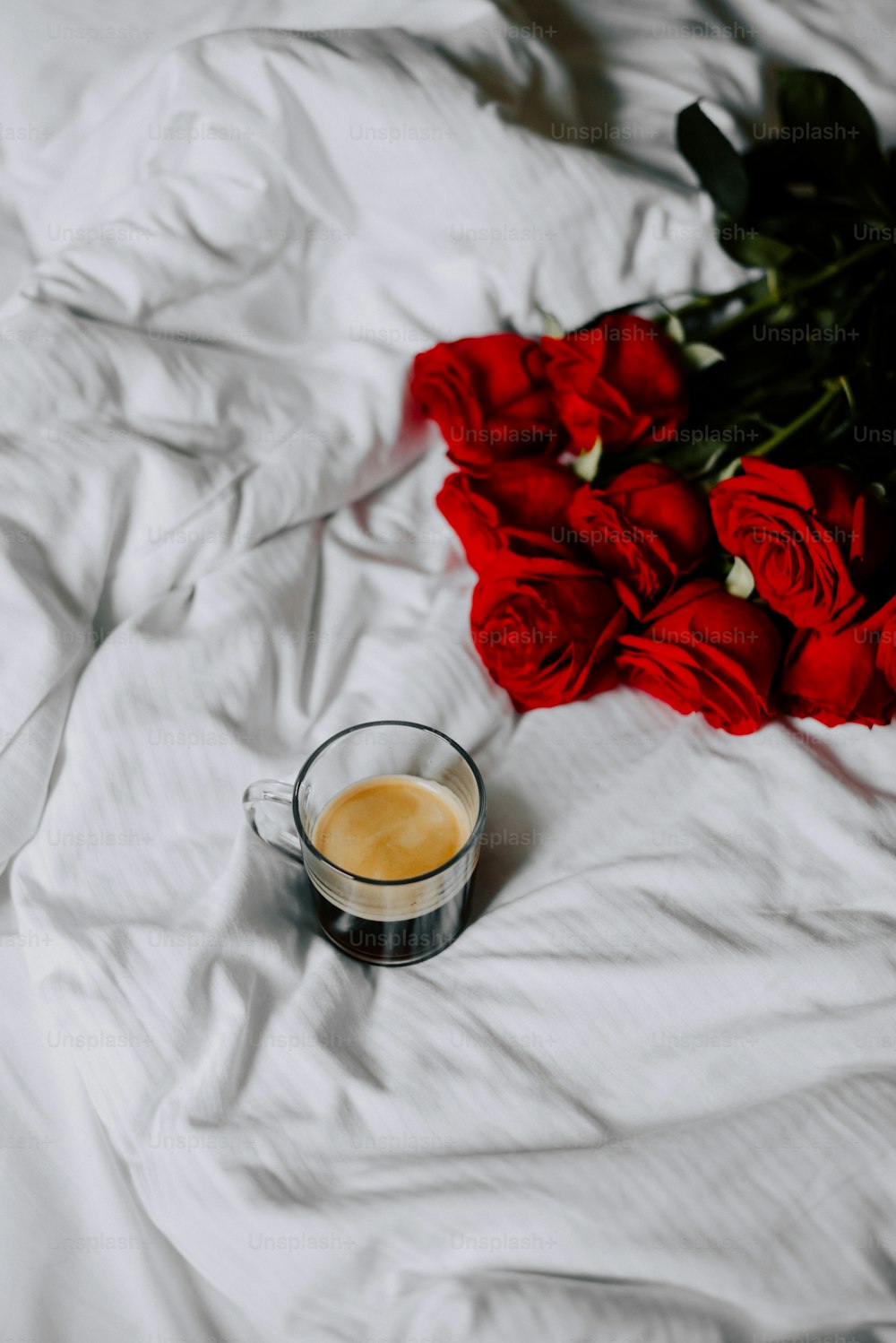 a cup of coffee sitting on top of a bed