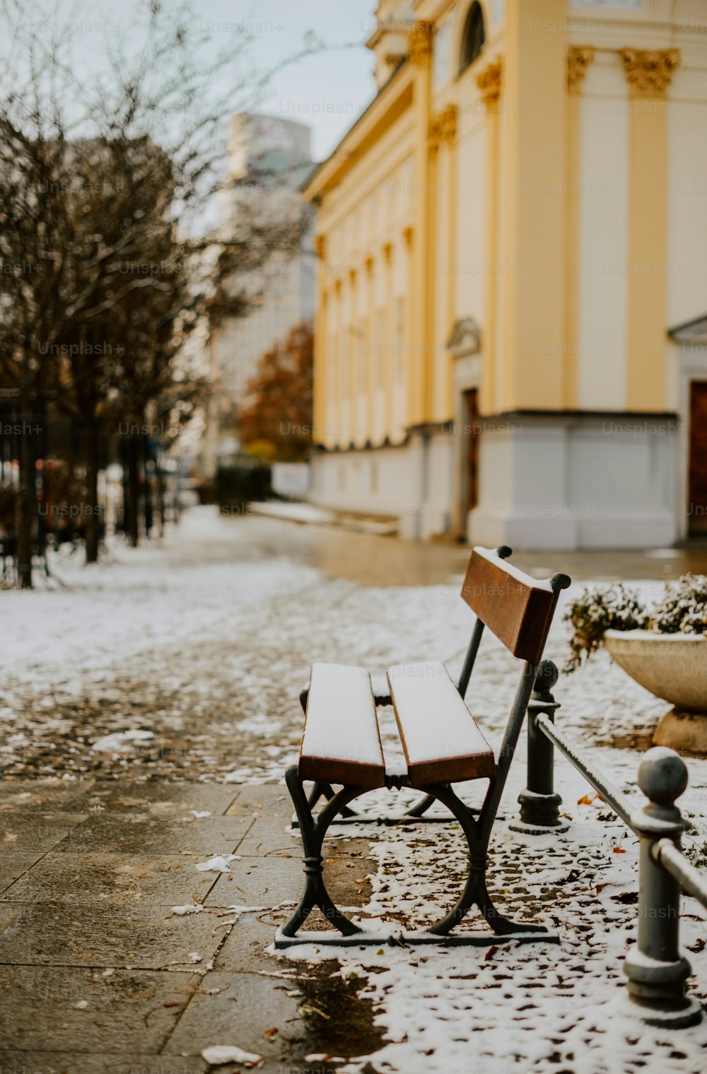 a wooden bench sitting on top of a sidewalk