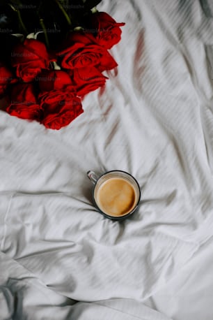 a cup of coffee sitting on top of a bed