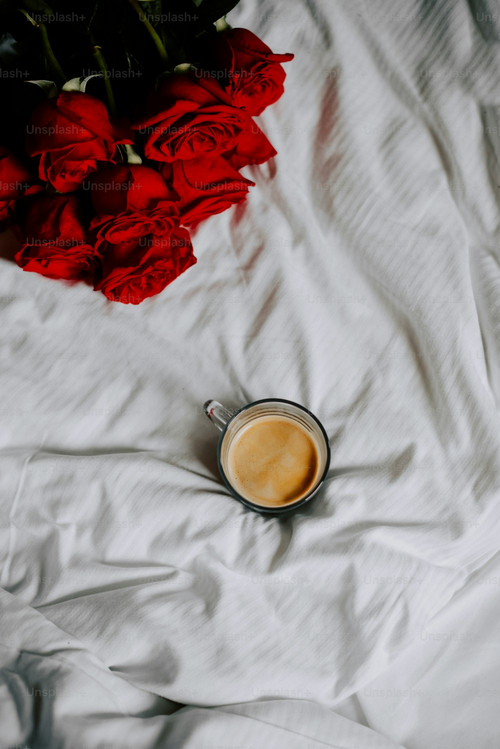 침대 위에 놓인 커피 한 잔