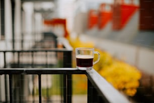 a cup of coffee sitting on top of a balcony