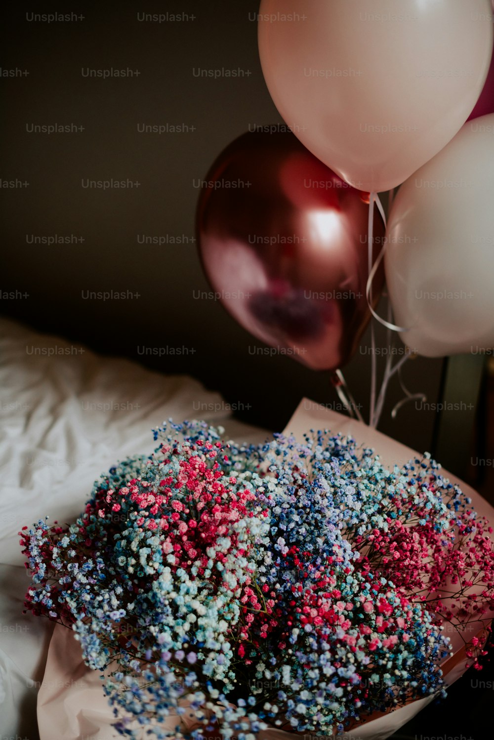 um buquê de sprinkles e balões em uma cama