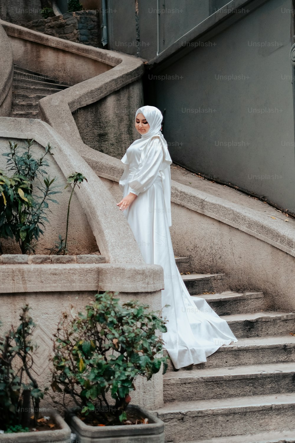 a woman in a white dress standing on some steps
