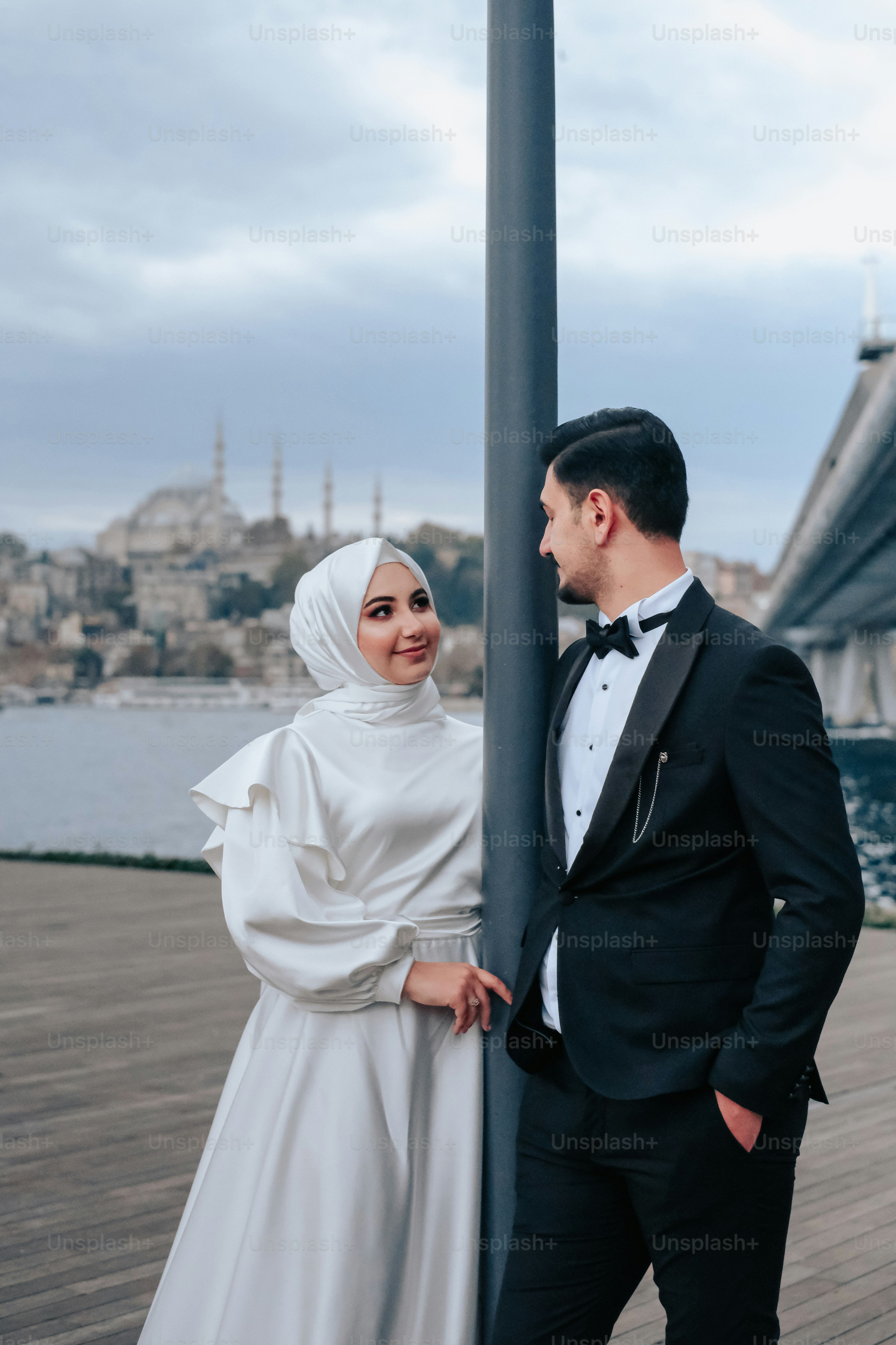 a man and a woman standing next to a pole