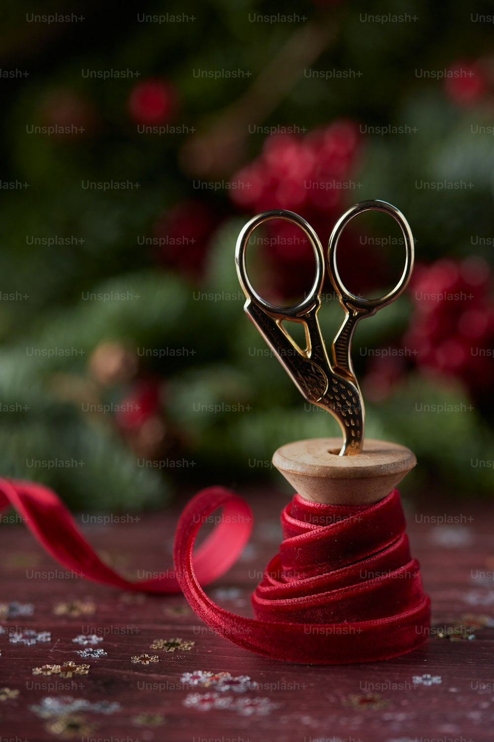 a pair of scissors sitting on top of a red ribbon