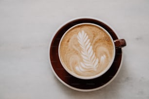 um cappuccino com uma folha desenhada