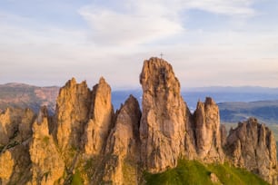 Una montaña rocosa con una cruz en la cima