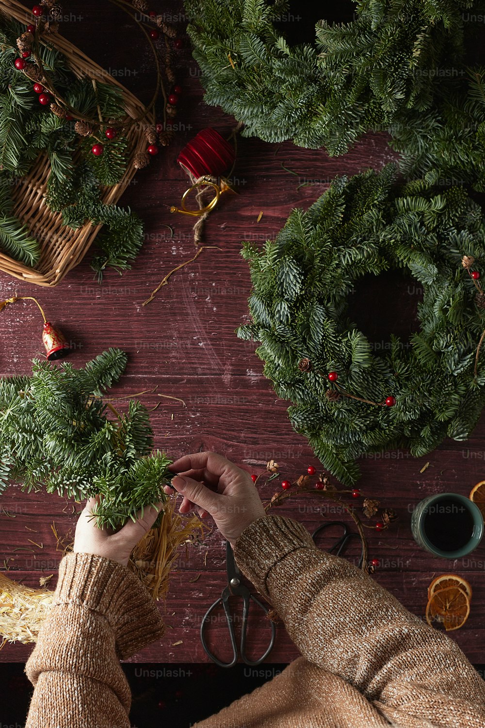 a person cutting a wreath with a pair of scissors