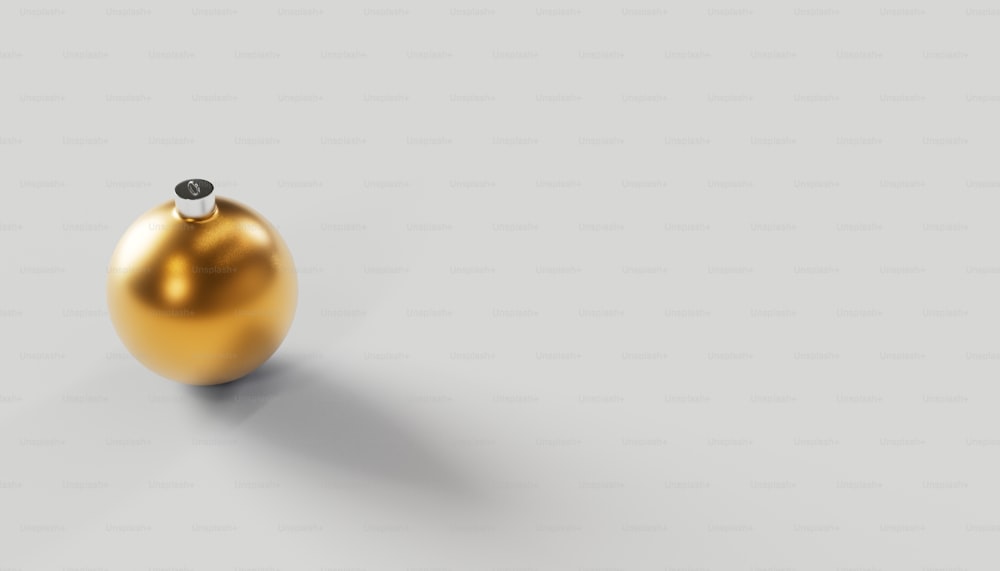 uma bola dourada com um topo preto em um fundo cinza
