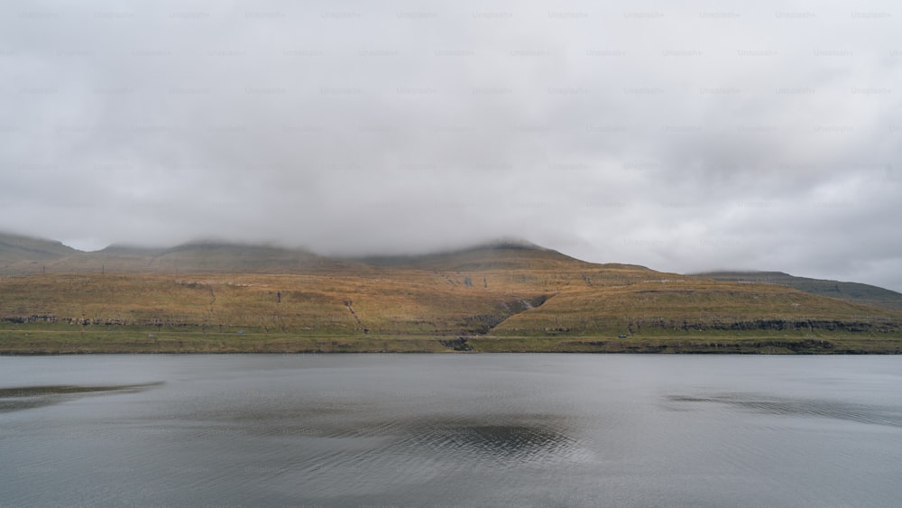 a body of water with hills in the background