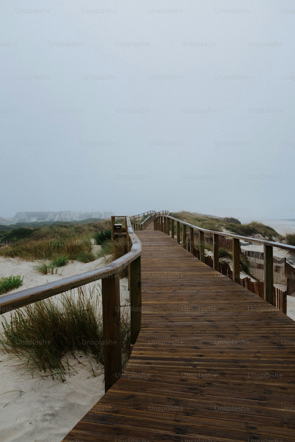 Un puente de madera sobre una playa de arena