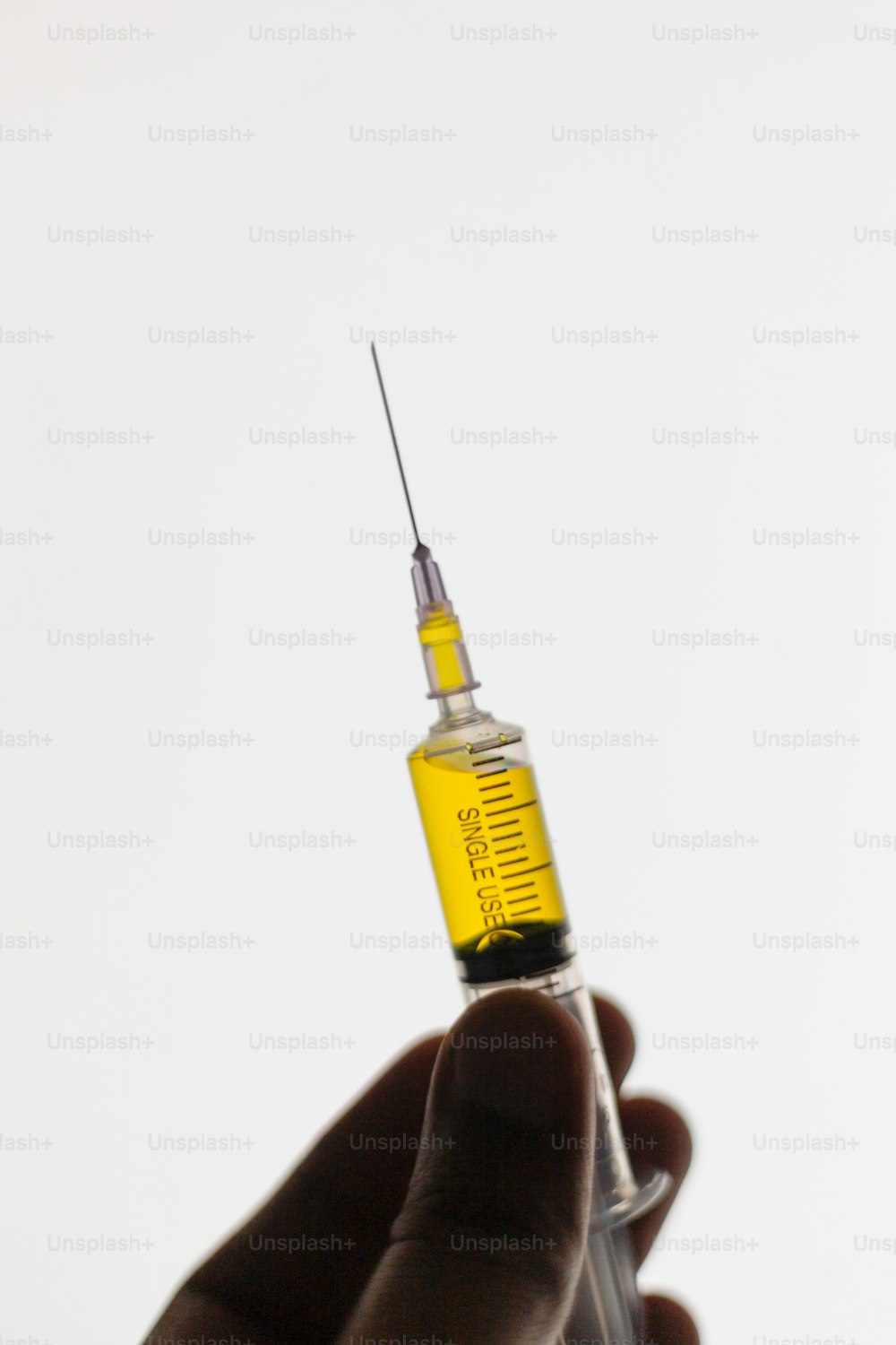 a hand holding a syringe