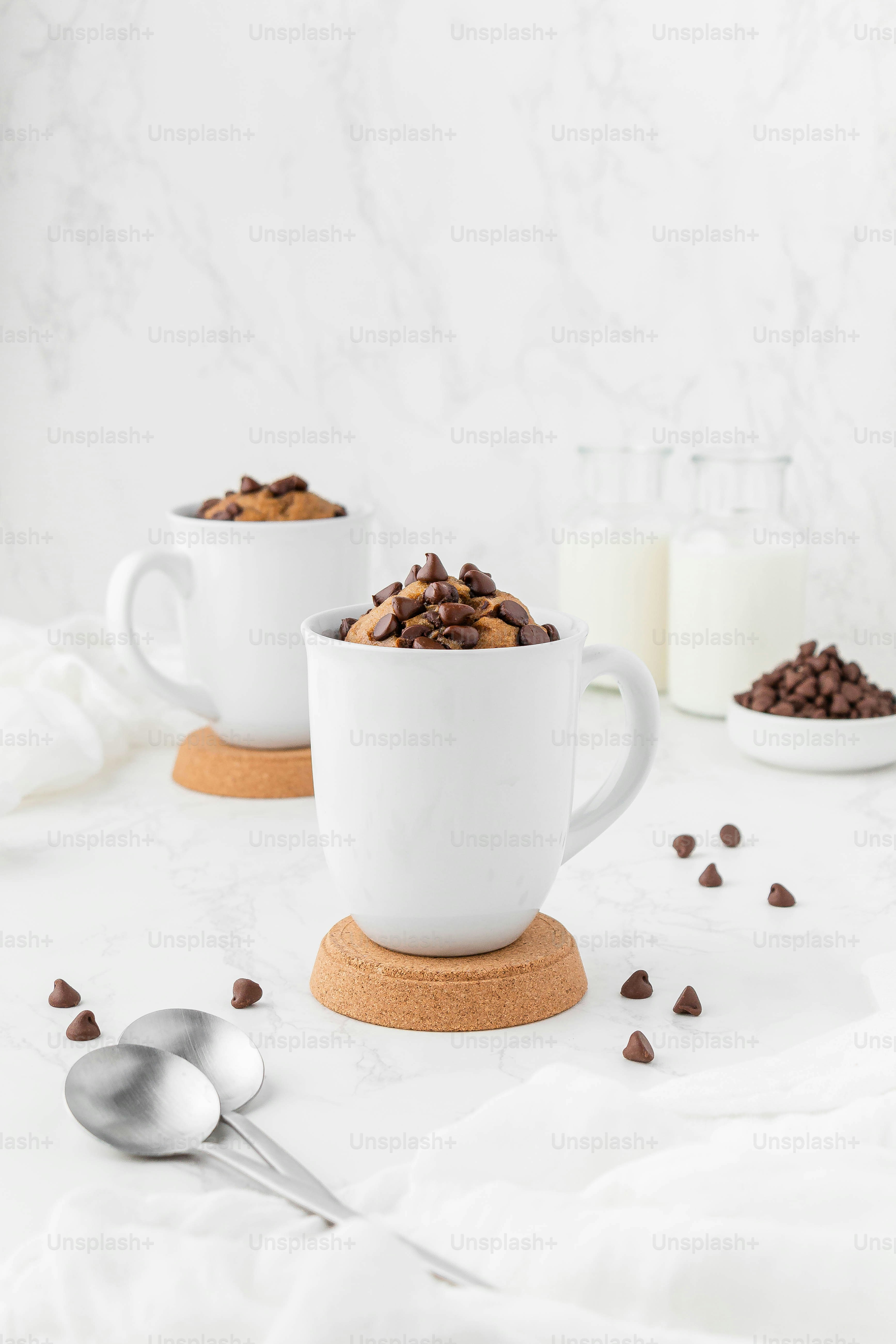 eine Tasse Kaffee mit einem Löffel und eine Tasse Kaffee