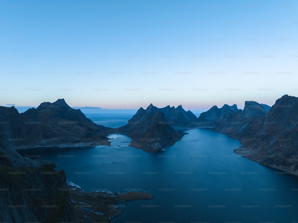a body of water with mountains in the back with Lofoten in the background