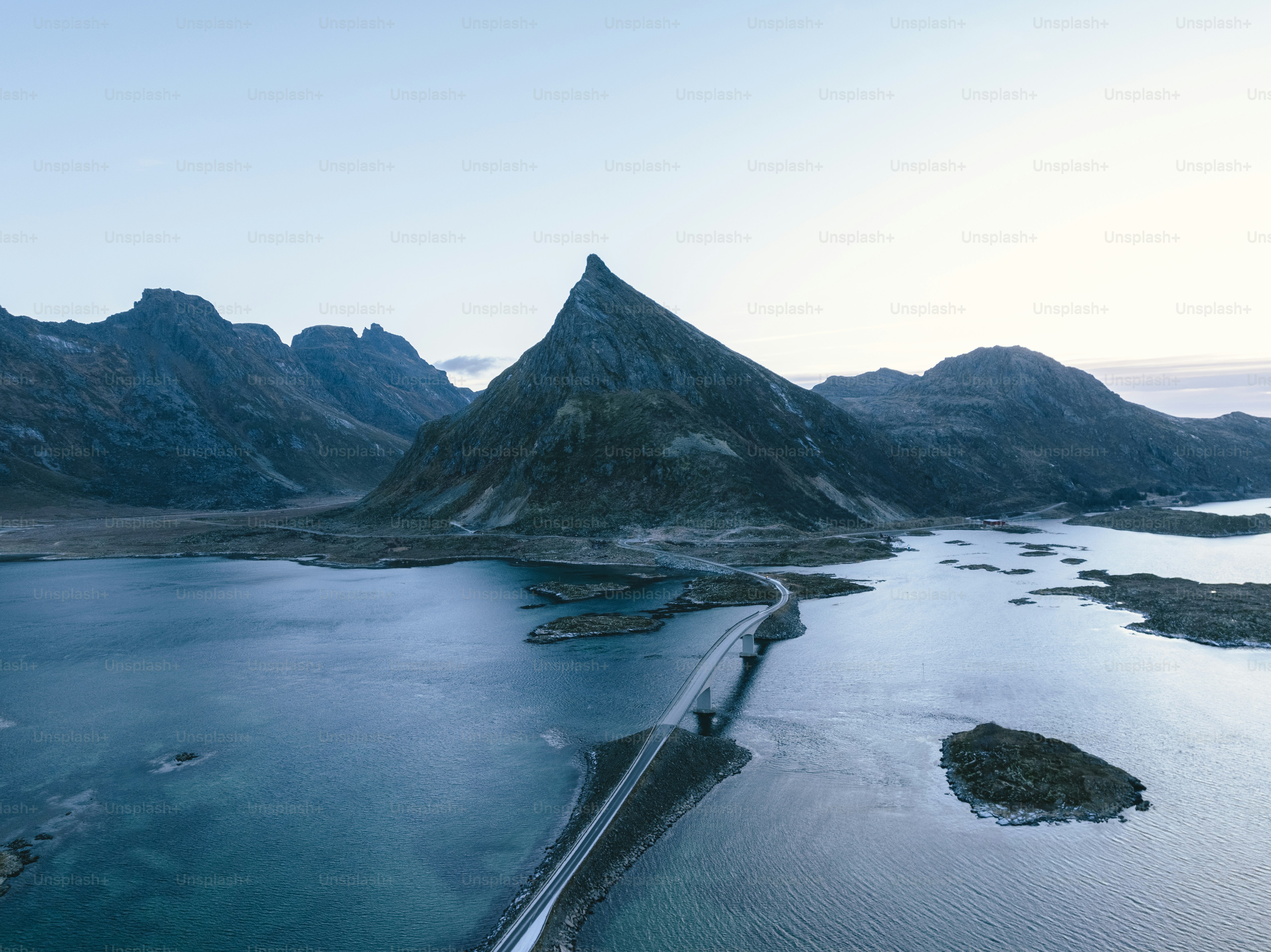 a long road going through a snowy landscape with Milford Sound in the background