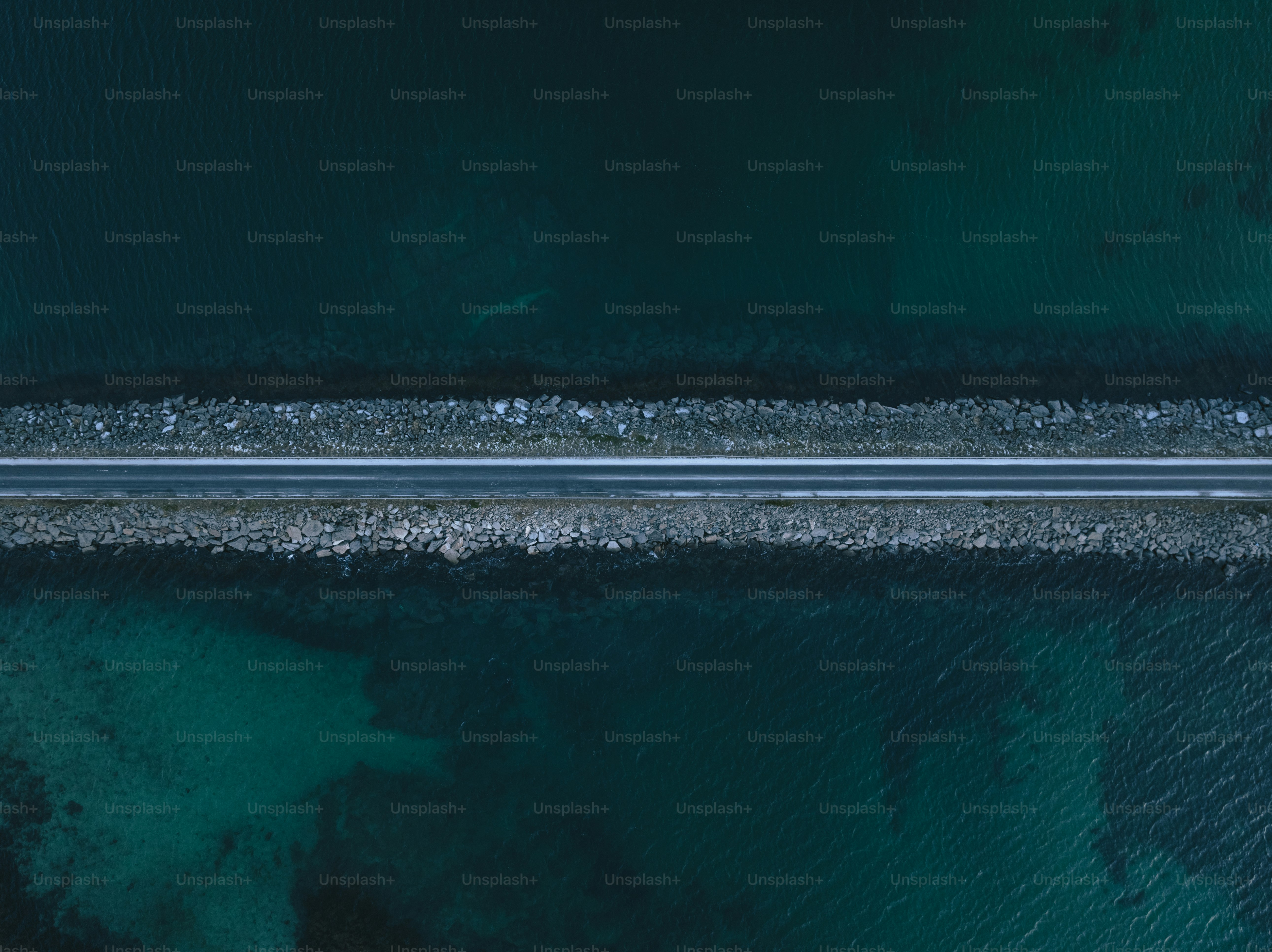 a body of water with a rocky shore and a dark sky