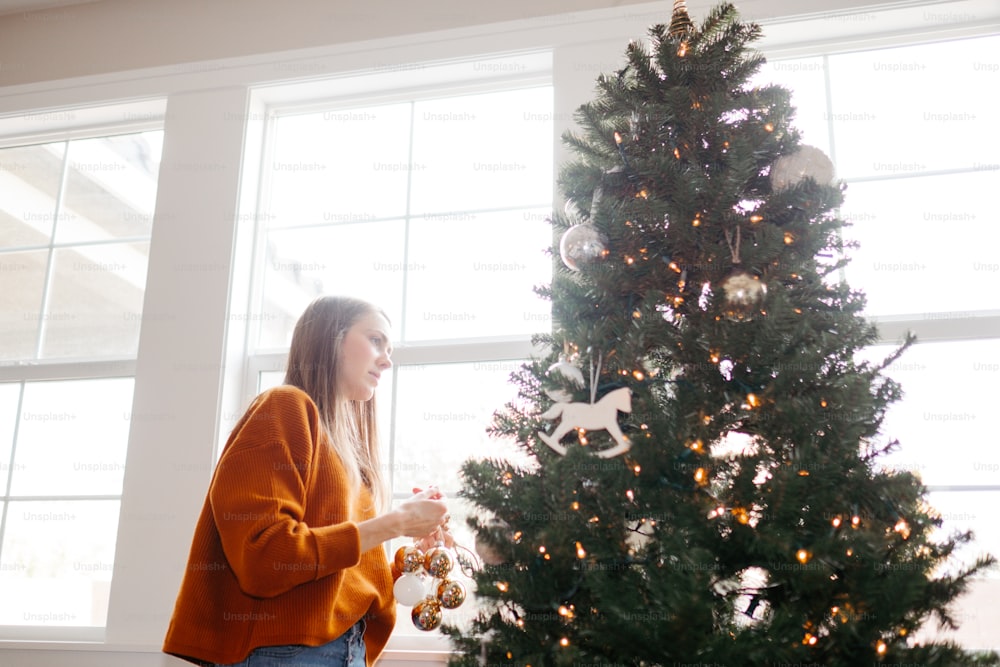 Eine Person, die neben einem Weihnachtsbaum steht