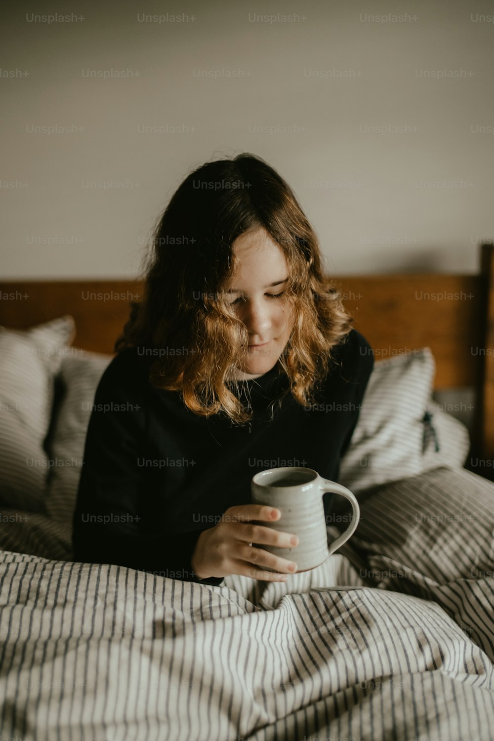 a person sitting on a couch holding a coffee cup