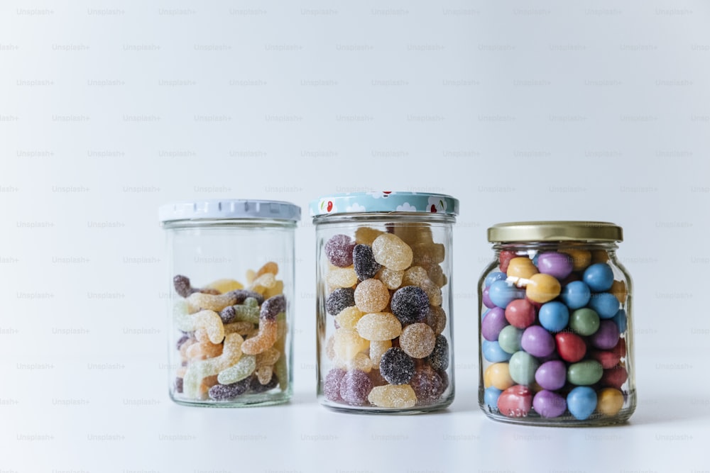 a group of glass jars with candy in them