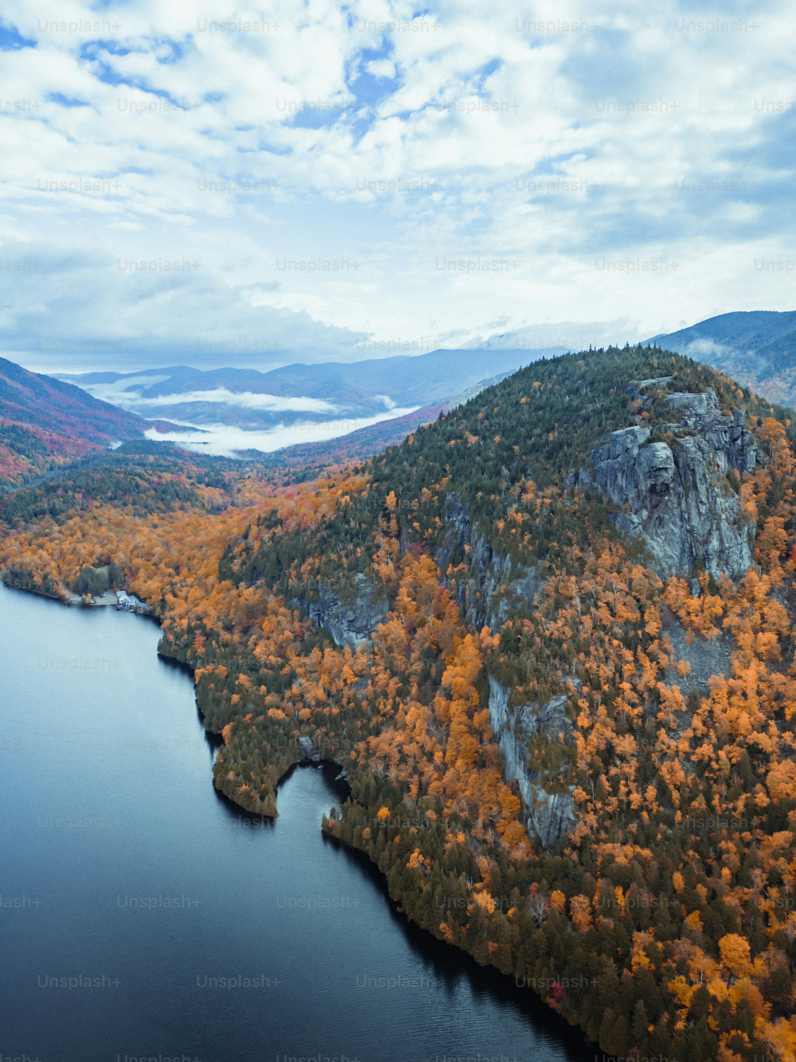 a body of water with a rocky shoreline and trees on the side