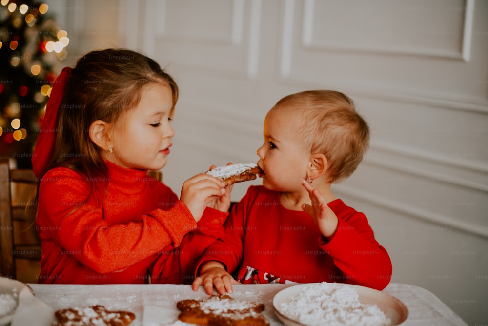 a couple of children eating pizza
