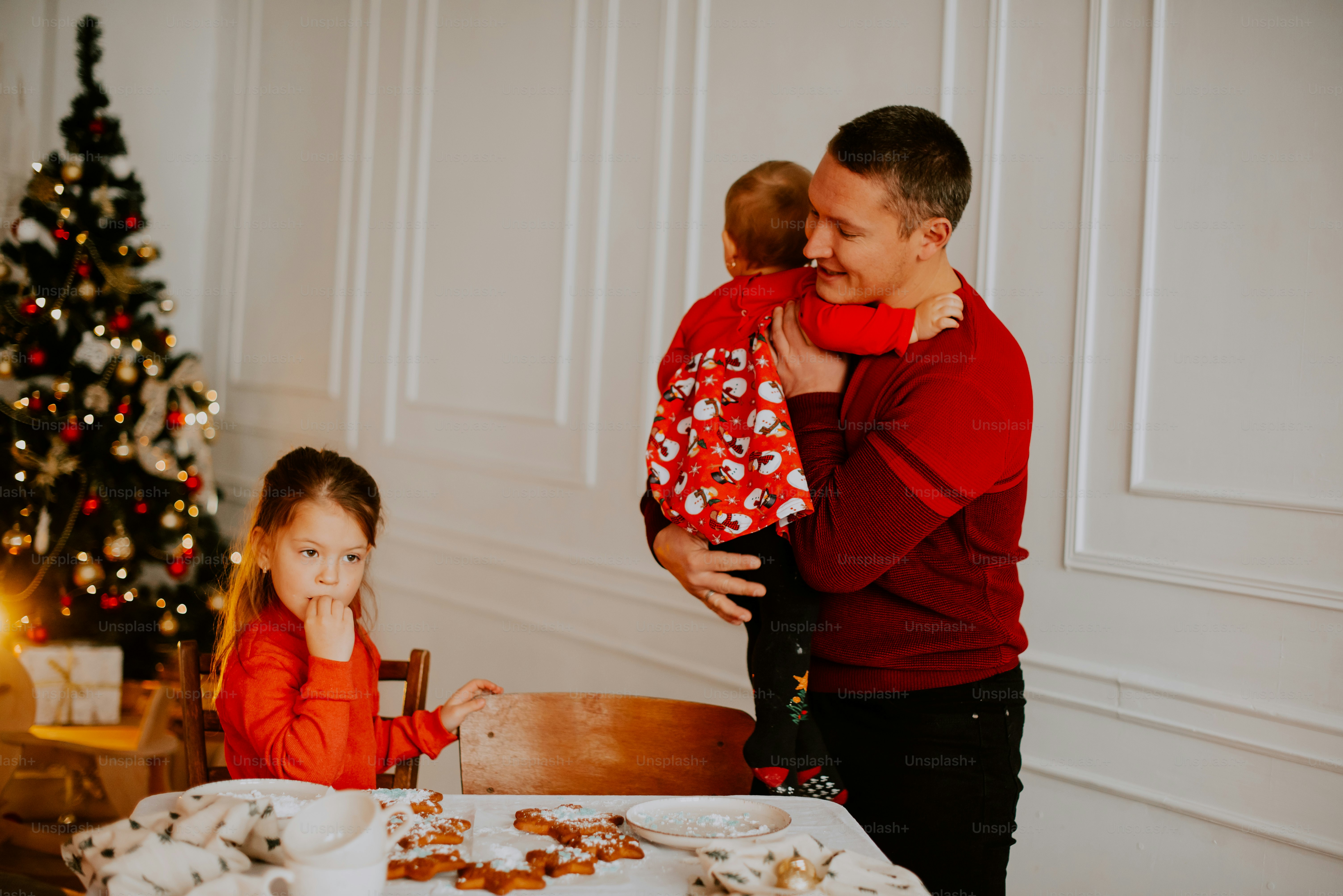 a man and a woman holding a child by a table with food