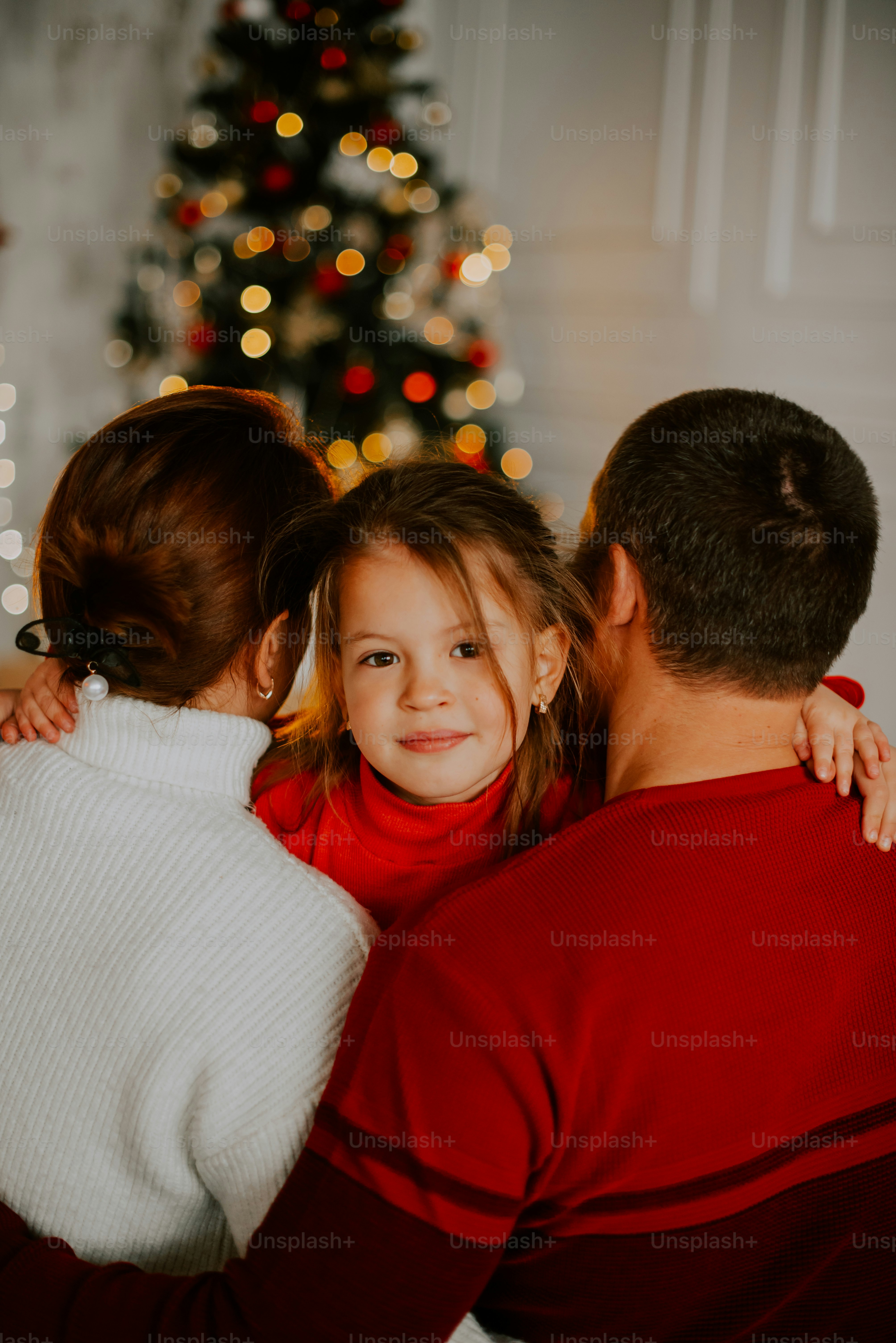 a group of people sitting in front of a christmas tree
