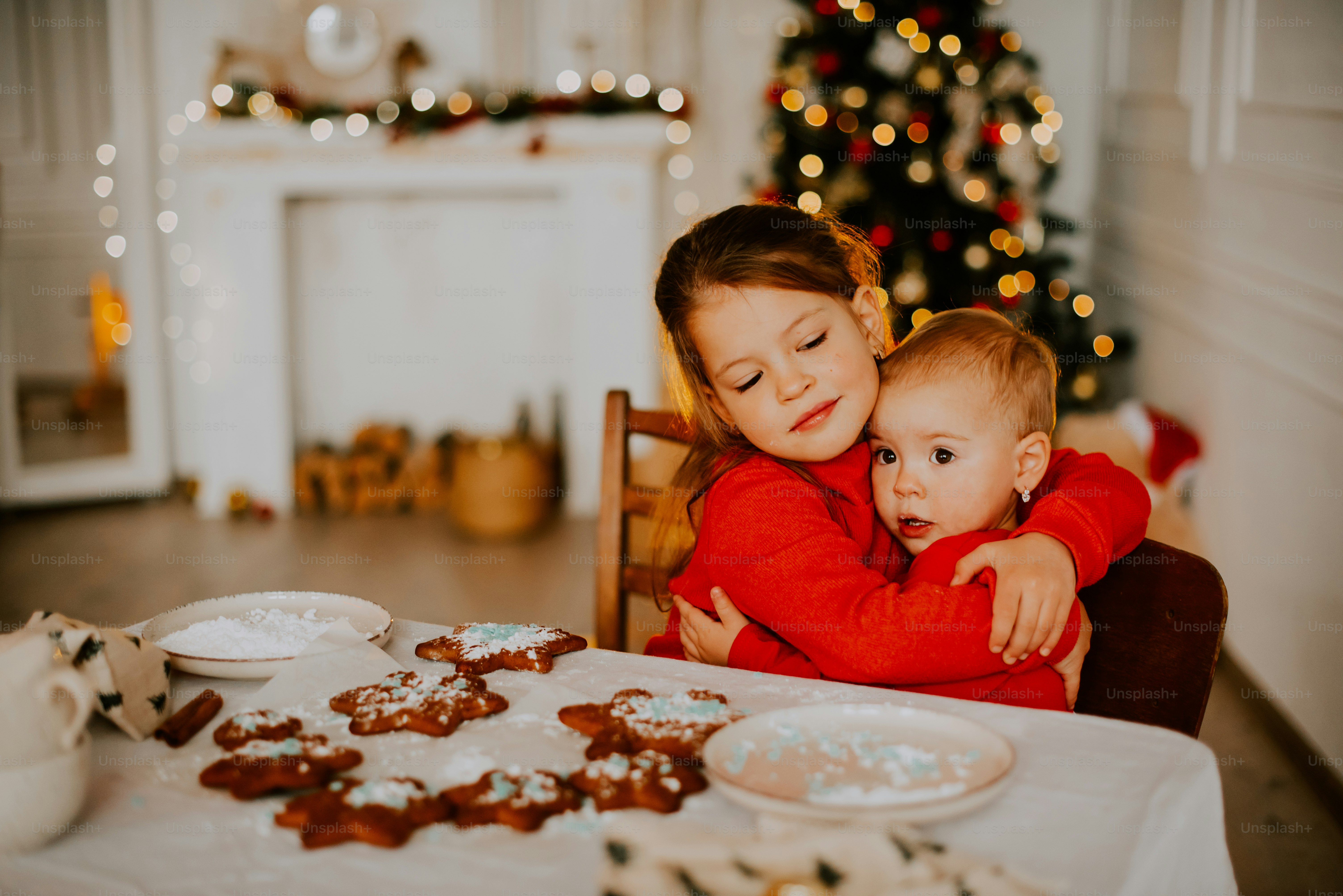 a person and a baby sitting at a table with food