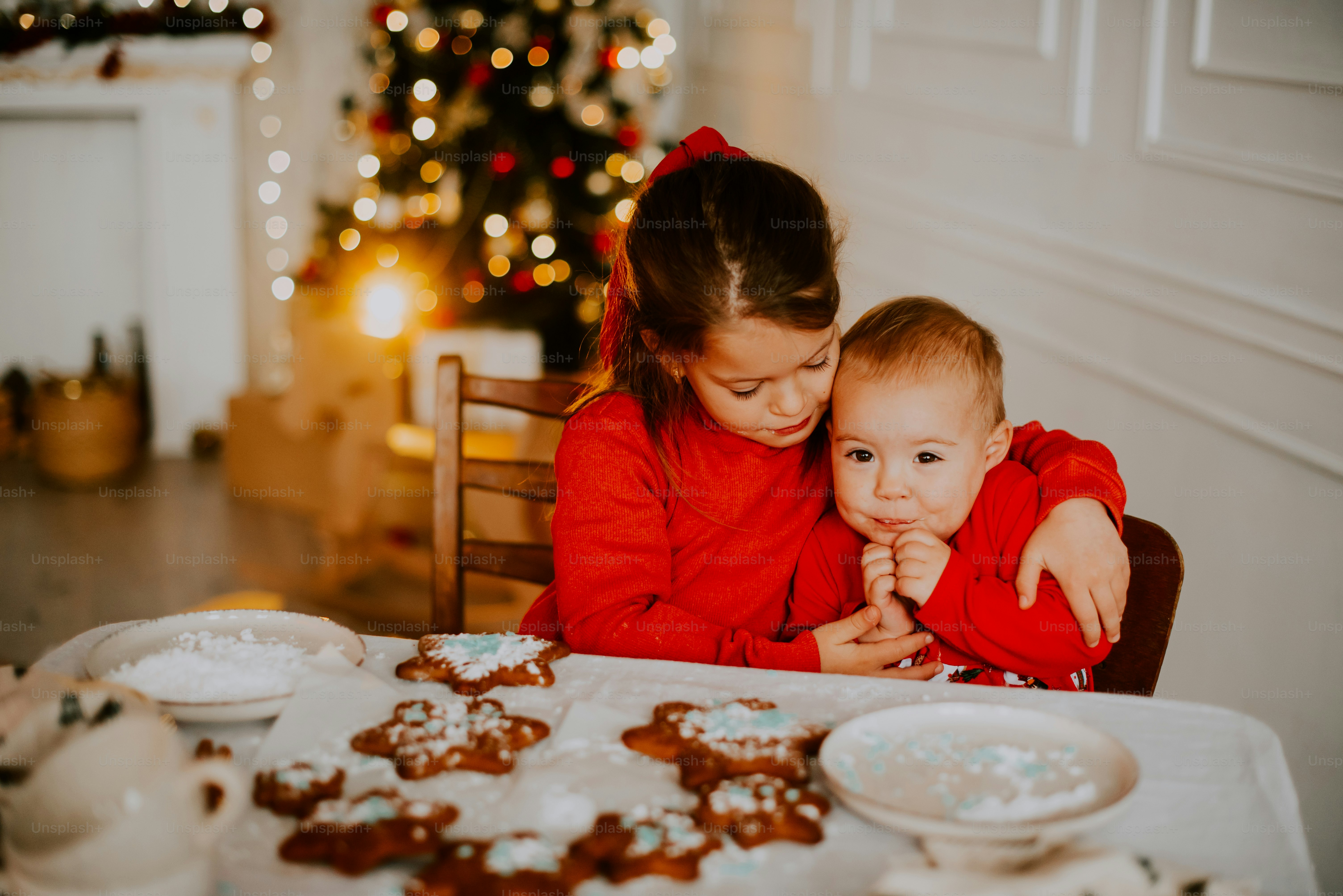 a person and two children sitting at a table with food
