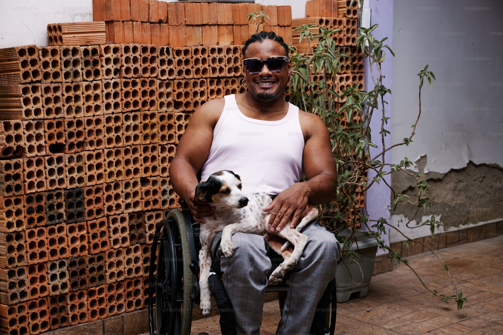 un homme assis sur une chaise tenant un chien