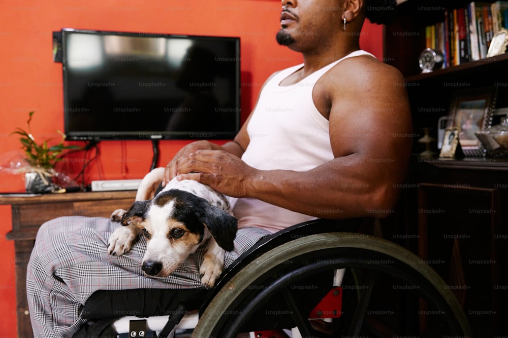 una persona su una sedia a rotelle che tiene un cane