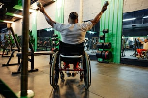 Un hombre en silla de ruedas levantando pesas