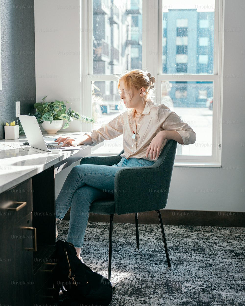 a woman sitting at a desk using a laptop