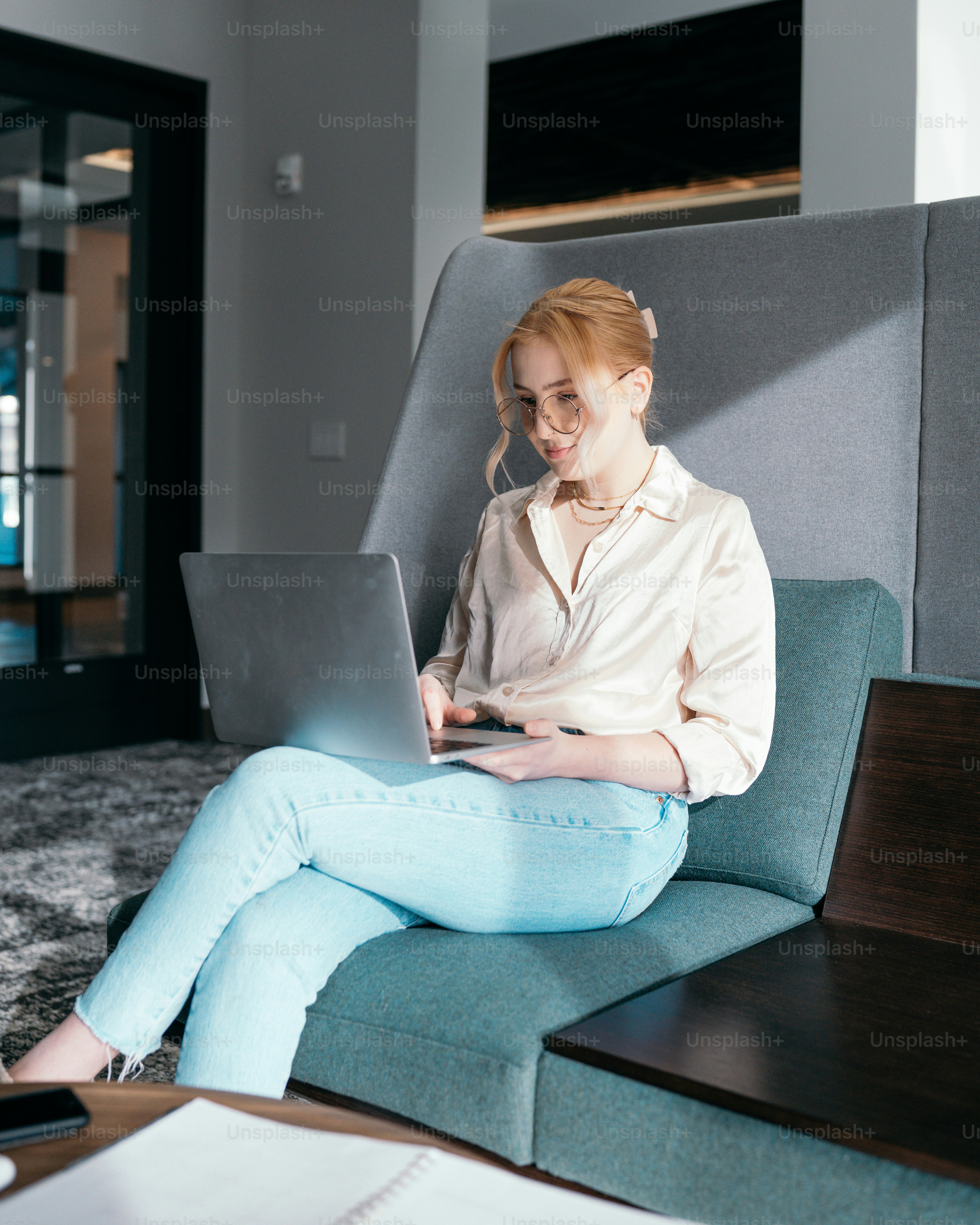 a woman sitting on a couch using a laptop