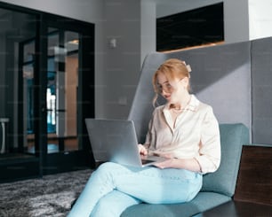 a woman sitting on a couch using a laptop