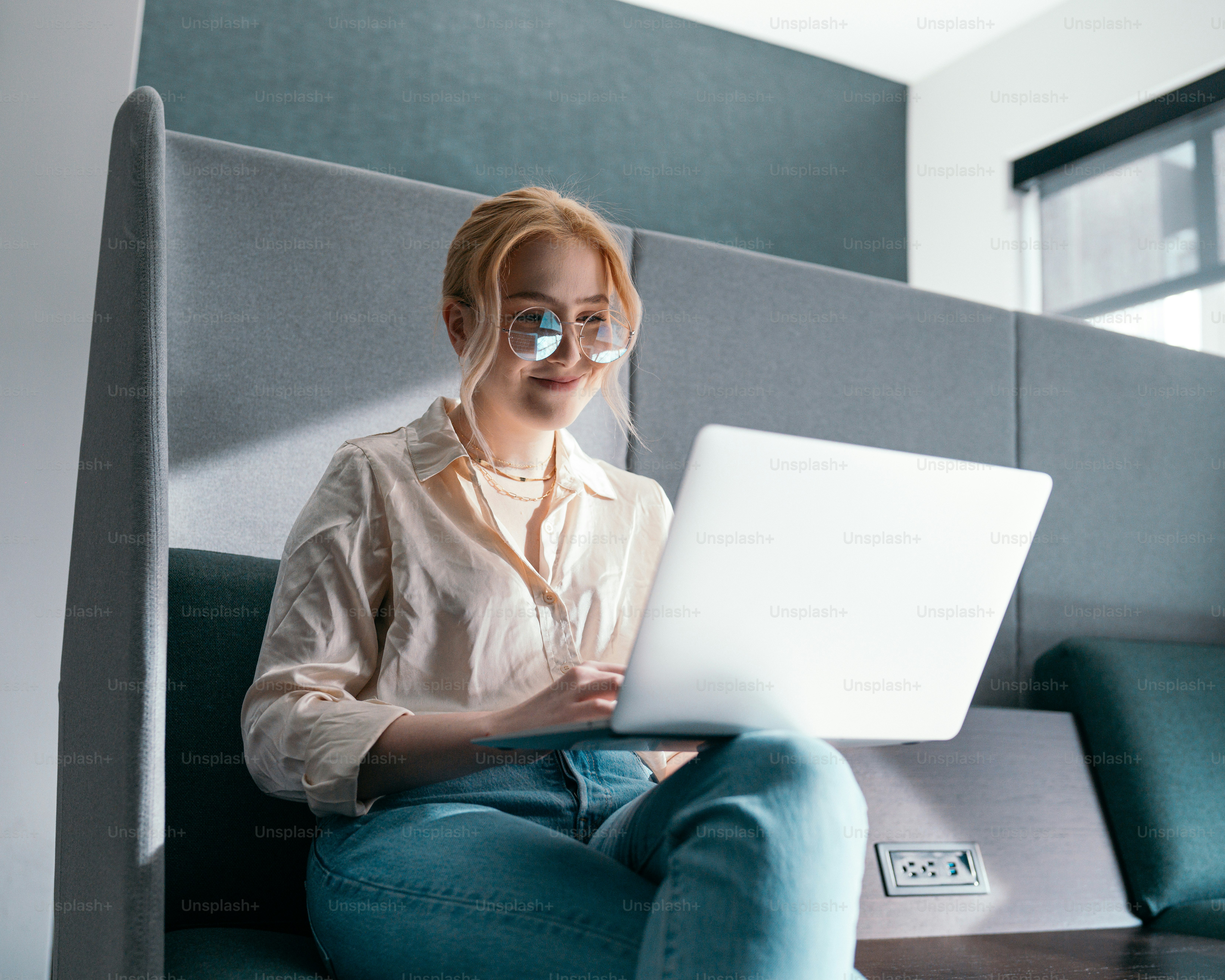 a woman sitting on a couch with a laptop